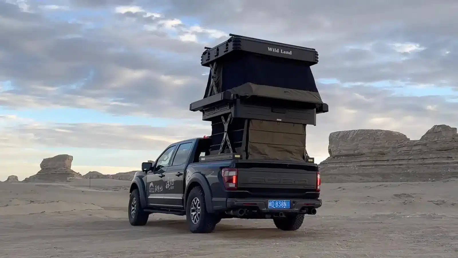 Wild Land Wingman two-storey camper raised on a Ford Raptor in a remote desert landscape