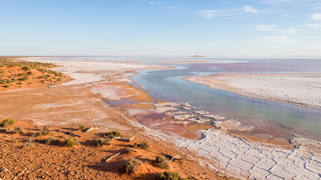 lake-eyre-south-aus Aerial view of Lake Eyre Kati Thanda water channel winding through red dunes and salt flats