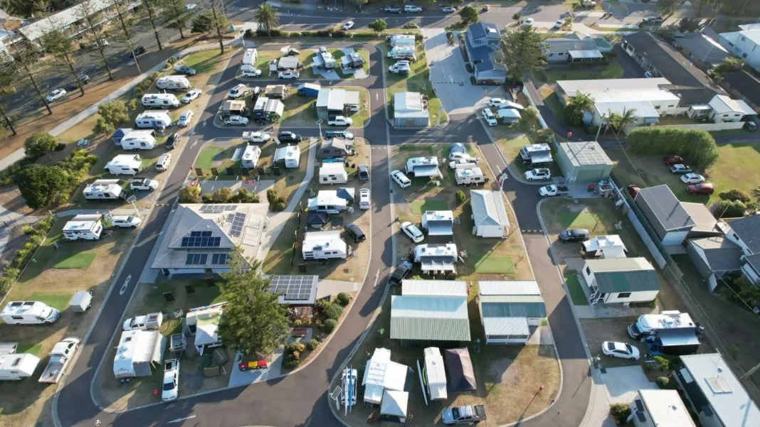 Aerial view of a busy caravan park with rows of vans, annexes and cabins along curving roads