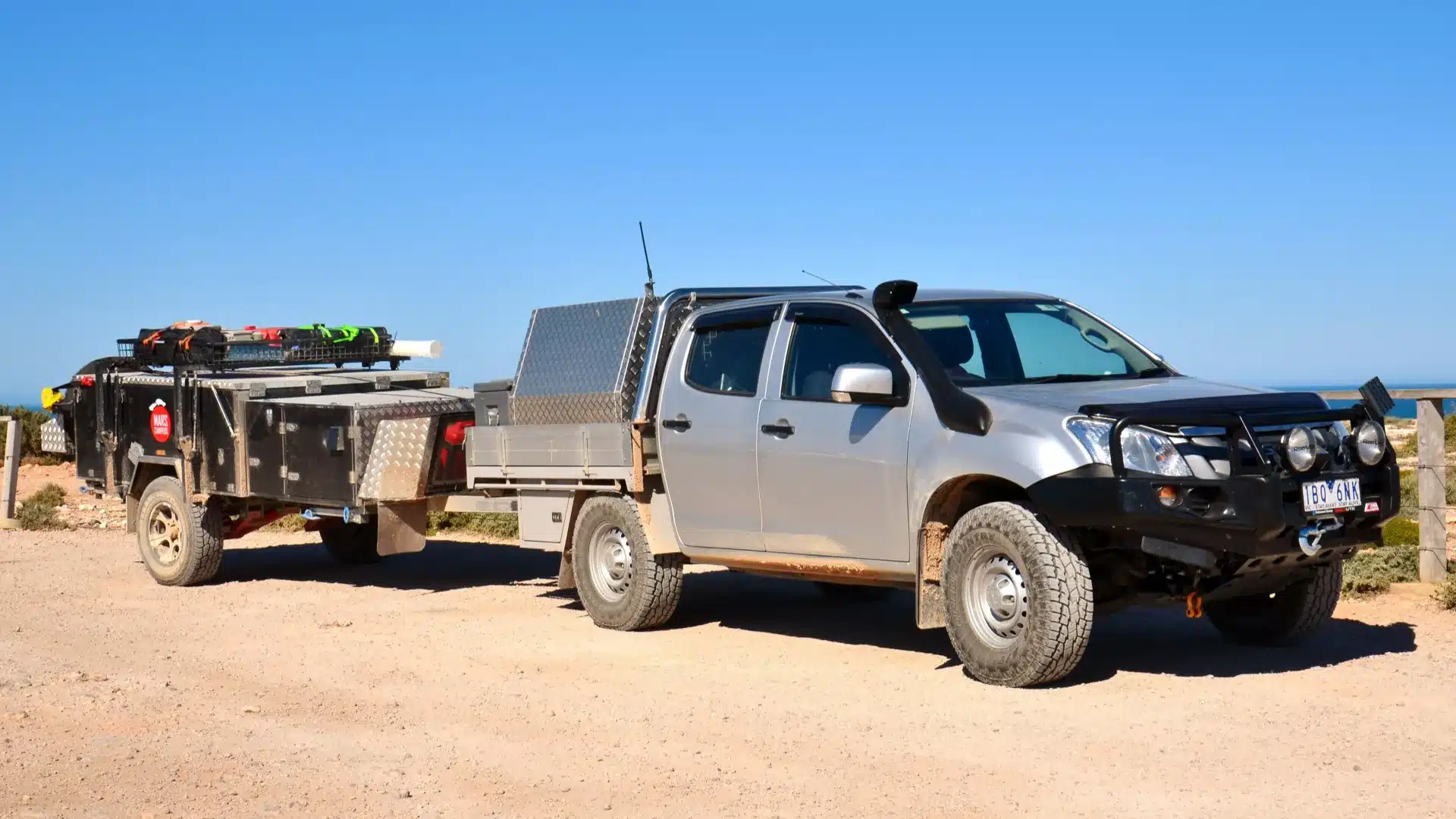 isuzu dmax camper trailer bunda cliffs nullarbor Silver Isuzu D-Max dual cab with a tray canopy hitched to a camper trailer at a clifftop lookout on the Nullarbor