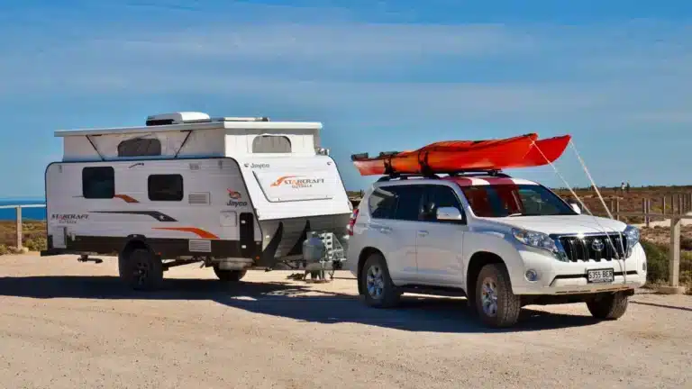 Toyota LandCruiser Prado hitched to a Jayco Starcraft Outback pop-top caravan at a Bunda Cliffs lookout on the Nullarbor