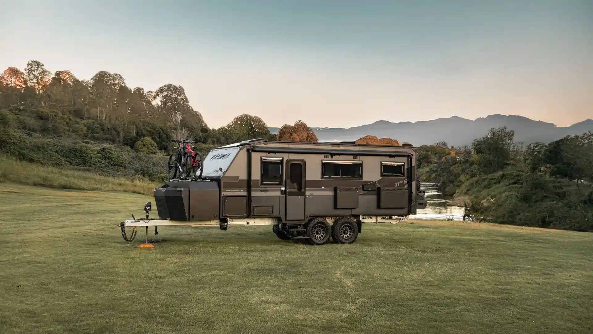 Titanium S4 off-road caravan Titanium S4 off-road caravan with bikes on the drawbar, parked on a grassy rise at dusk with hills behind