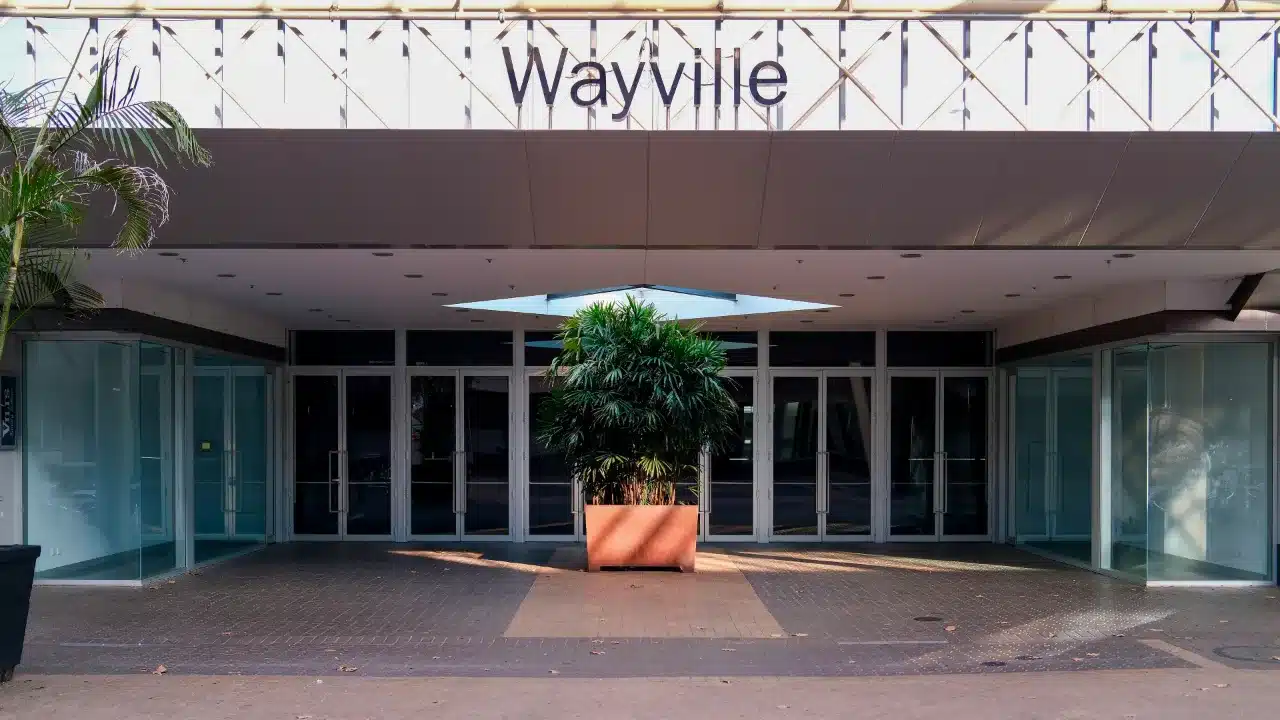 Glass entrance of the Wayville Pavilion at the Adelaide Showground, with a potted palm under the sign