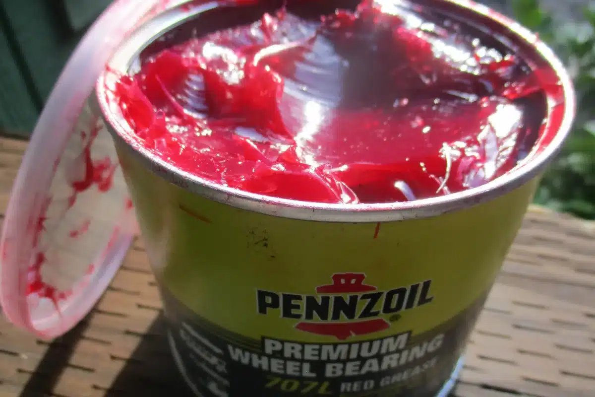 Open tin of red wheel bearing grease with its plastic lid pulled back